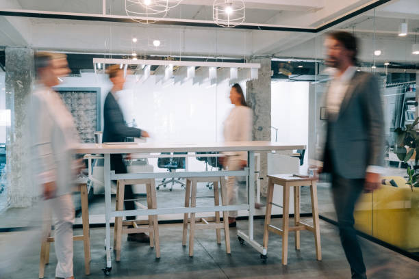 istock Modern office interior with blurred business colleagues. 1362265162