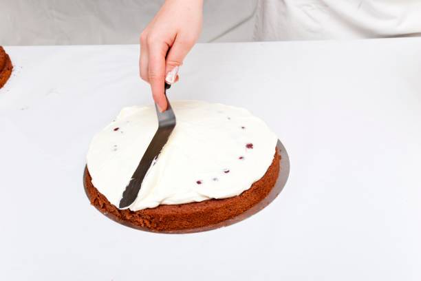 istock Spreading whipped cream on top of a layer cake with cherries 1362272866