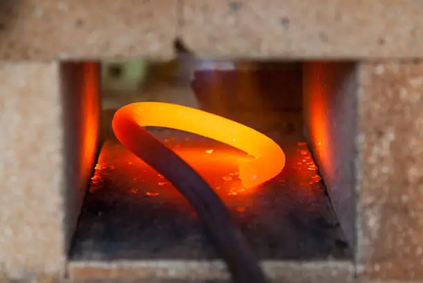round steel being heated for further bending