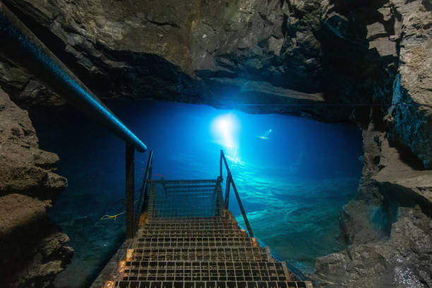 istock Cave divers training deep cave dives in old coal mine lake. Light from cold blue water 1362293306