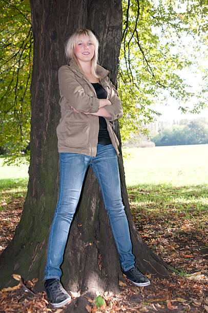 istock young woman stands on a tree 136229332