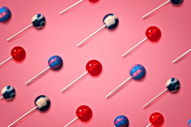 This is a repetitive pattern of colorful lollipops on a pink background