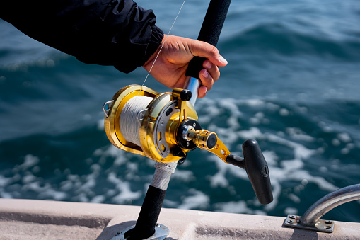 Ocean fishing reel on a boat fishing for big game fish on a sunny day such as Mahi-mahi, dorado, tuna, sailfish, swordfish sharks and marlin. They are used in tropical and cold water oceans.