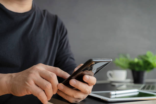 istock Happy Young Man Uses Smartphone while Sitting on a Sofa at Home. 1362302483