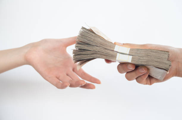 Close up of people giving packs of Thai baht money to other person isolated on white background. Thai baht is the official currency of Thailand. bribing stock pictures, royalty-free photos & images