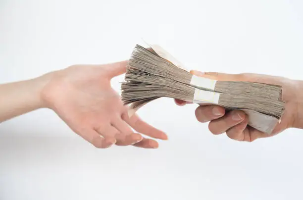 Photo of Close up of people giving packs of Thai baht money to other person isolated on white background.