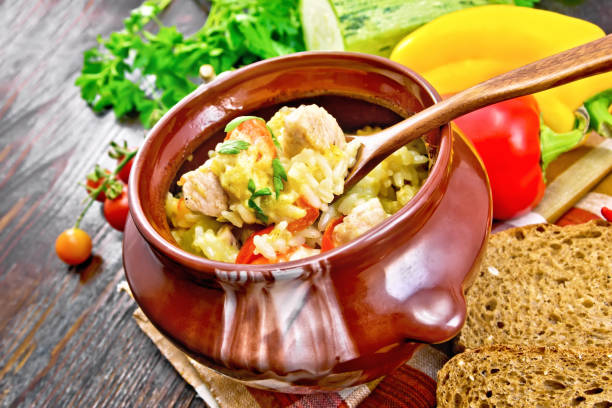Rice with chicken and vegetables in pot on board