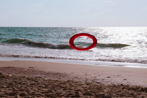 red frisbee thrown along the beach on a sunny day