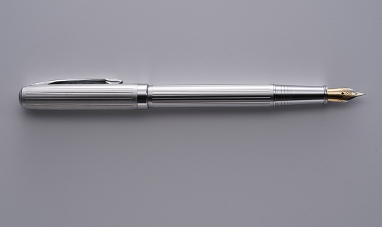 silver fountain pen on gray background