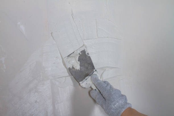 istock Apply plaster white putty on a concrete wall with a spatula 1362320252