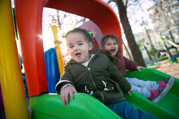 istock Two little kid girls having fun on the plastic slide. 1362323779