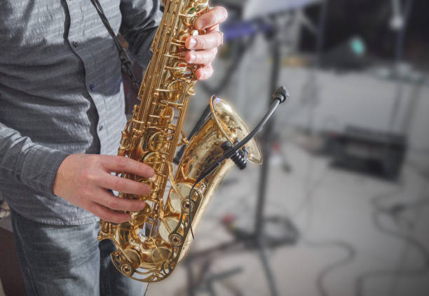 istock Saxophone playing. Hands of a man playing the saxophone. Dark background. Copy space. 1362323944