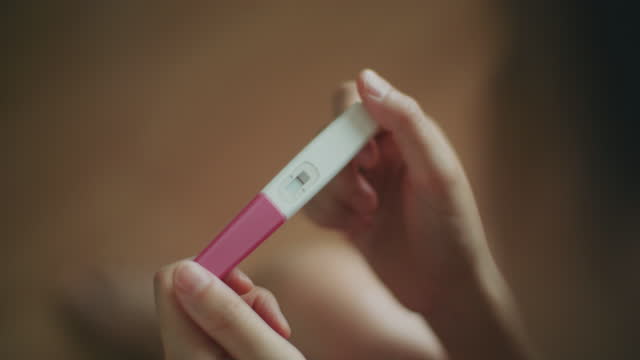 Sad young woman looking upset after taking a pregnancy test at home