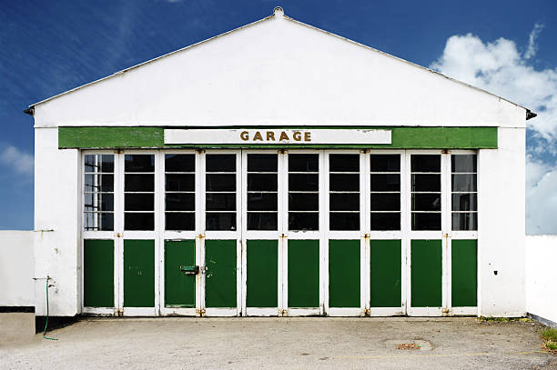 alte verlassene auto repair garage gegen blauen himmel - automotive repair center stock-fotos und bilder