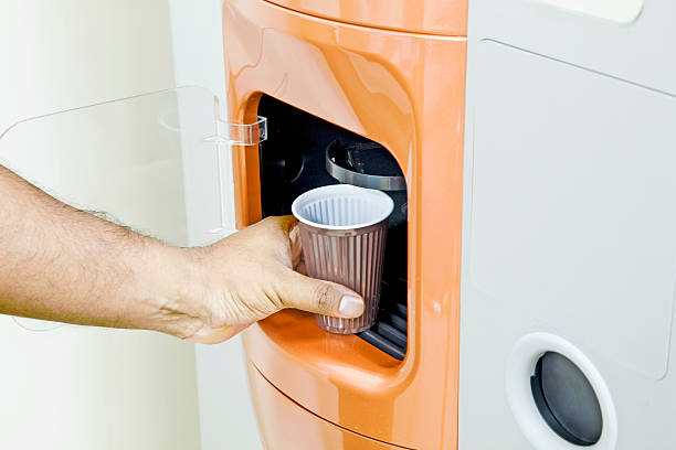 Getting some fresh coffee out of a machine vending machine drinks. vending machine photos stock pictures, royalty-free photos & images