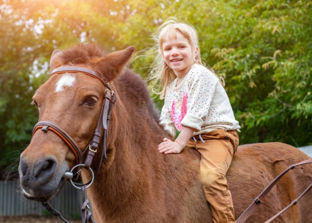 счастливая маленькая девочка верхом на лошади голой спиной - horse child pony little girls стоковые фото и изображения