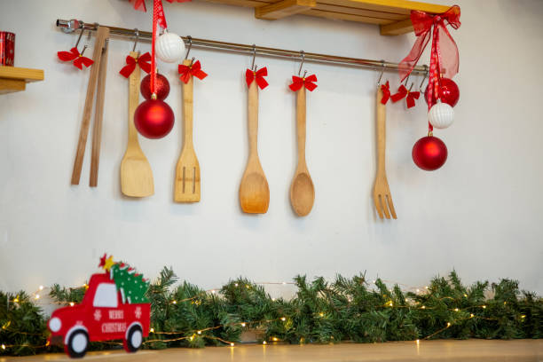 Kitchen wooden countertop with hob and kitchenware decorated for winter holidays new year christmas