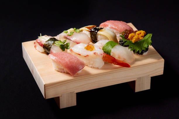 un delicioso sushi de agarre montado en la geta - nigiri fotografías e imágenes de stock