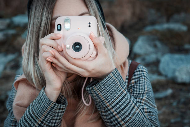 istock Woman hands holding a pink instax camera 1362347062