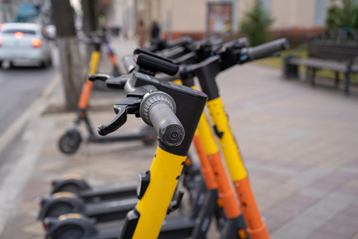 Transporte urbano eléctrico. La fila de eléctricos se prepara para montar bicicletas scooter con acumuladores en el centro de una ciudad en la piedra del pavimento photo