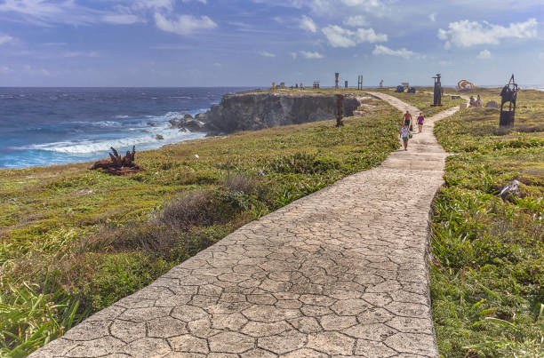 Stone way of sea promontory #2 Isla Mujeres, Mexico 2 January 2022: Stone path crosses a green garden with the background of the sea: The panorama at Isla Mujeres in Mexico isla mujeres stock pictures, royalty-free photos & images