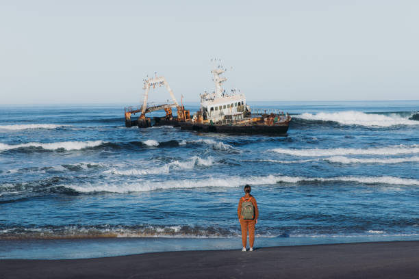 istock Female backpacker exploring the scenic Skeleton coast with shipwreck 1362361539