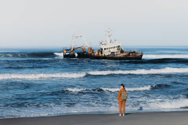 istock Female backpacker exploring the scenic Skeleton coast with shipwreck 1362361553