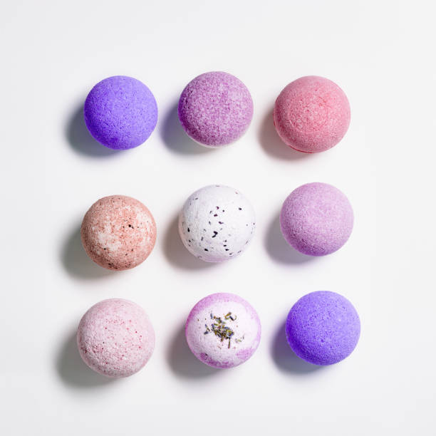istock Flat lay composition with bath bombs pink, violet, purple colored on white paper background. Bathing balls with  essential oils for relaxation and aromatherapy. Body care natural products 1362364289