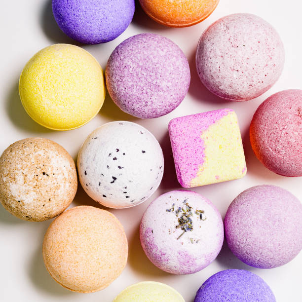 istock Flat lay composition with bath bombs pink, violet, purple colored on white paper background. Bathing balls with  essential oils for relaxation and aromatherapy. Body care natural products 1362364291