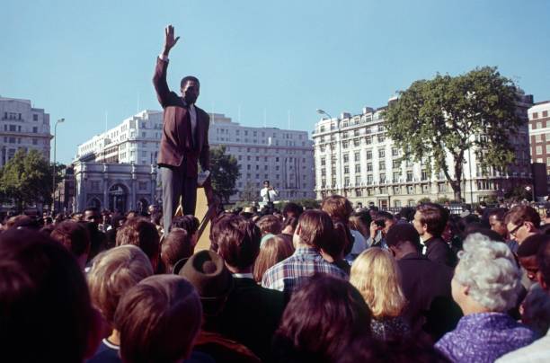 London, England, UK, 1980. Speakers Corner in London Hyde Park. A man gives a speech to interested park visitors. Another speaker in the background.