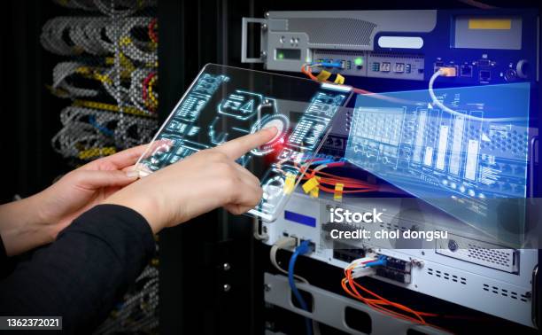 Woman Holding Ar Device Panel And Analyzing System In Server Room Stock Photo - Download Image Now