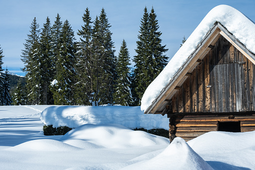 Wooden alpine cabin in beautiful idyllic winter landscape. Seasons, weather, holidays and travel concepts