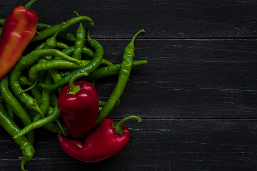 Green pepper and red pepper on wood