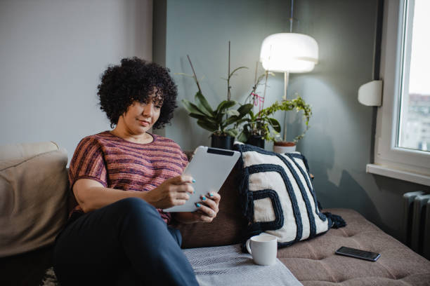 istock Mid adult woman at home, using tablet 1362378458