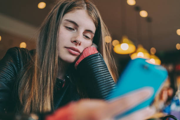 istock Bored teenager in cafe texting 1362378478