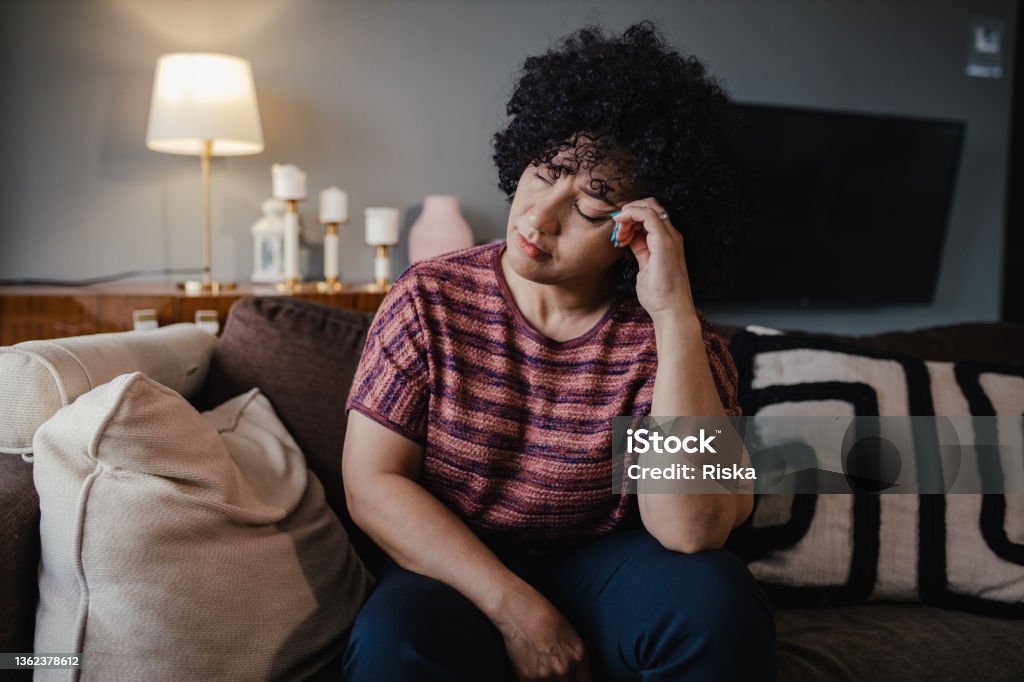 Portrait of mid adult woman feeling depressed Photo of mature woman at home, feeling sad Women Stock Photo