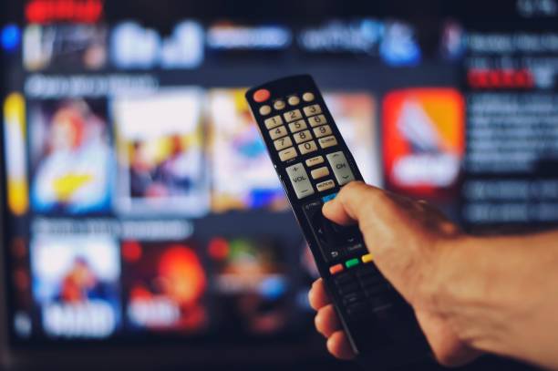 istock Male hand holding tv remote control. 1362379784