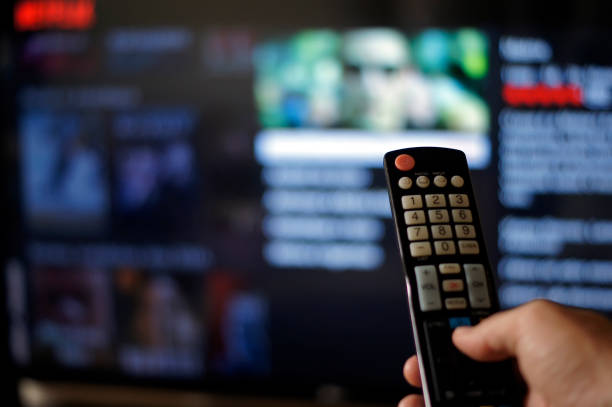 istock Male hand holding tv remote control. 1362379786