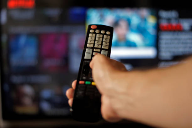 istock Male hand holding tv remote control. 1362379787