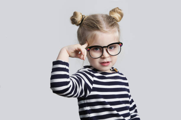 kleiner nerd, der mit dem finger auf den kopf zeigt, studioaufnahme - child glasses eyewear little girls stock-fotos und bilder