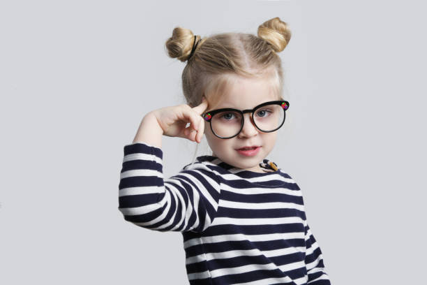 mały nerd wskazujący palcem na jej głowę, ujęcie studyjne - child glasses eyewear little girls zdjęcia i obrazy z banku zdjęć