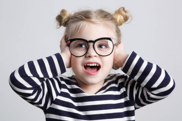 istock Cute little nerd child covering ears with hands and screaming, studio shot. 1362380991