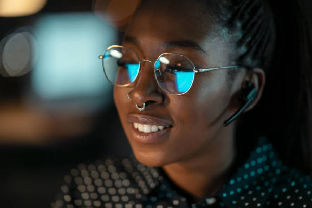 istock Smart business woman working with computer while talking with earphone sitting in modern startup office. 1362381017