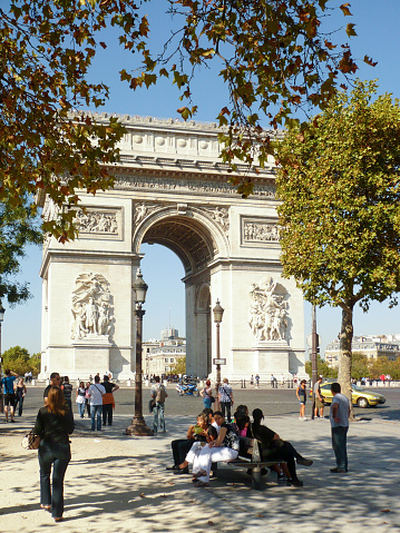 Paris, France - October 3, 2020: Unidentified people at the western end of the Avenue des Champs-Elysees with very famous monument 
