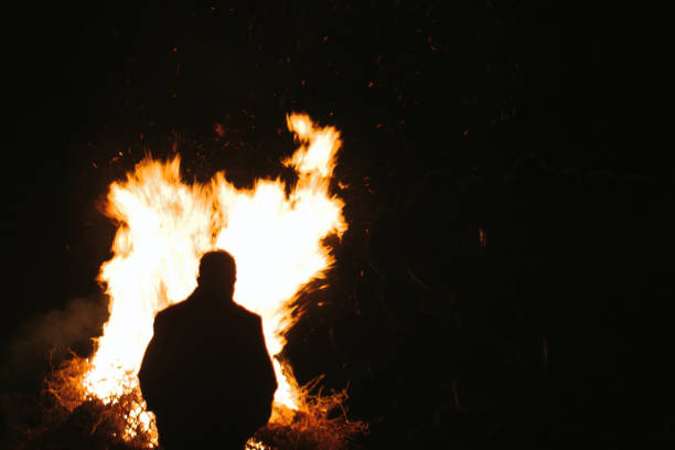 istock Silhouette man stand in front of fire 1362387283