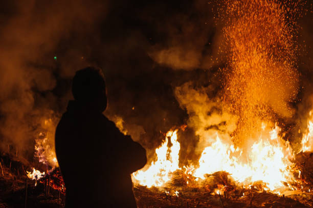 istock Silhouette man stand in front of fire 1362387290
