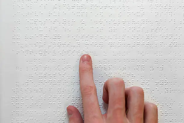 A person reading braille text with their hand