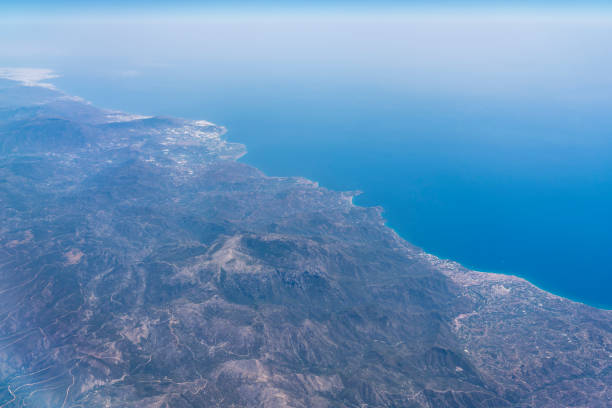 Aerial view from the airplane on volcanic landscape of Tenerife island and sea.