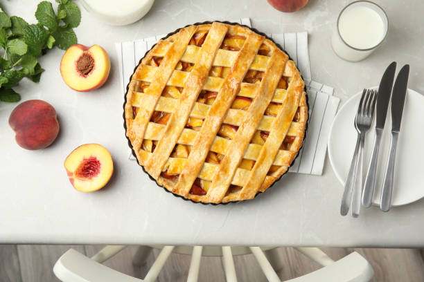 istock Delicious fresh peach pie served on light kitchen table, flat lay 1362397142