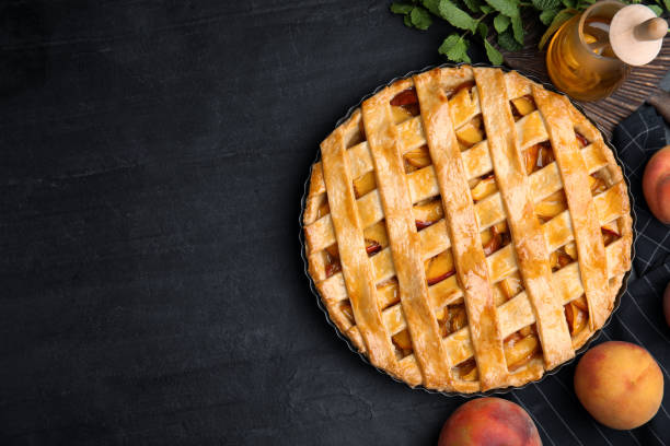 istock Delicious peach pie and fresh fruits on black table, flat lay. Space for text 1362398389